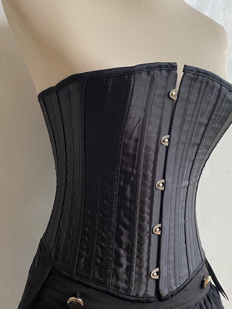 Black Corset with Bones (Category: Sets or Coordinates) located in Tumauini. Submitted by bihisbyme (Listing ID 1450880516, Image 3). Description: - Black corset with front clasps and lace-up back - Satin-like finish with vertical stitching - Attached short, ruffled black skirt - Decorative buttons on skirt - Adjustable fit for a custom look - Ideal for costumes or a bold fashion statement Issue: please check photo Overall, still useful. .