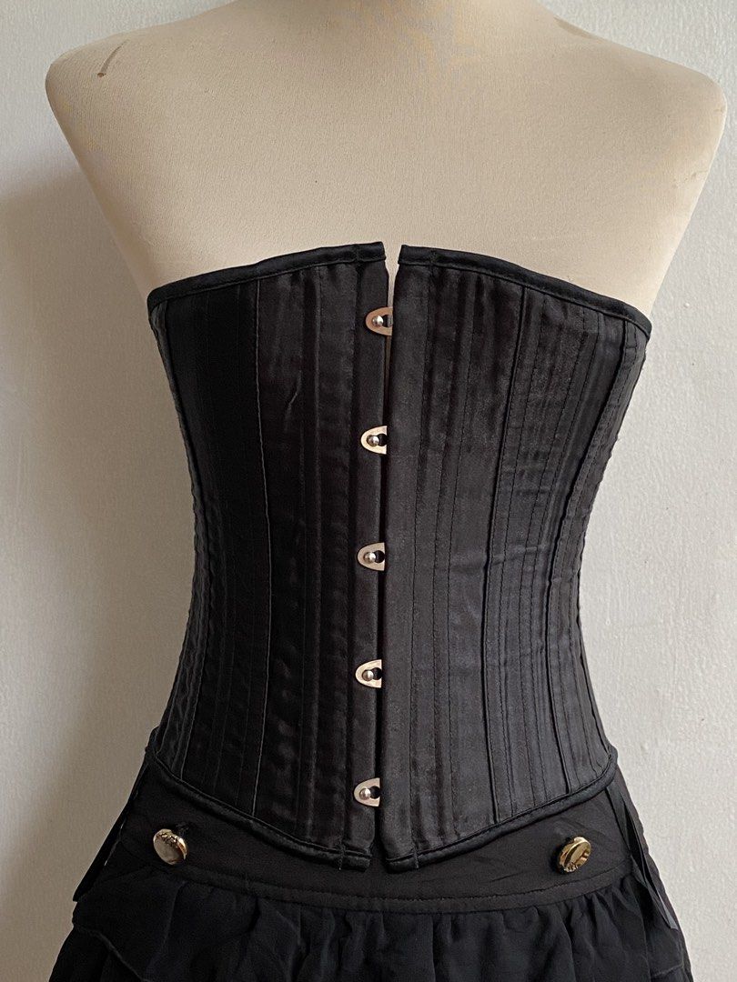 Black Corset with Bones (Category: Sets or Coordinates) located in Tumauini. Submitted by bihisbyme (Listing ID 1450880516, Image 2). Description: - Black corset with front clasps and lace-up back - Satin-like finish with vertical stitching - Attached short, ruffled black skirt - Decorative buttons on skirt - Adjustable fit for a custom look - Ideal for costumes or a bold fashion statement Issue: please check photo Overall, still useful. .