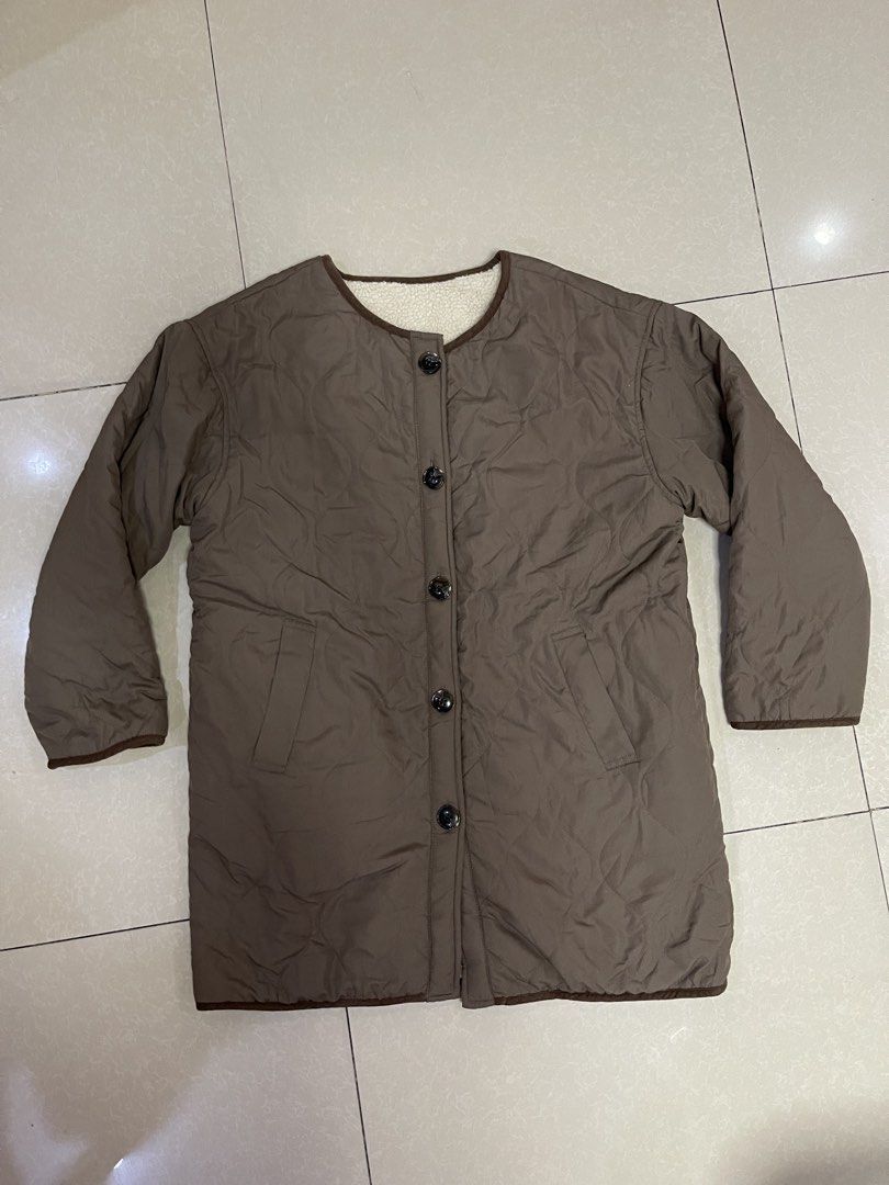 Brown Quilted Button-Up Jacket with Sherpa Lining (Category: Coats, Jackets and Outerwear) located in Manila. Submitted by offtherack_mnl (Listing ID 1450758185, Image 1). Description: - Brown quilted jacket - Cozy sherpa lining - Button-up front - Two side pockets - Brown piping trim on collar - Ideal for layering in cooler weather.