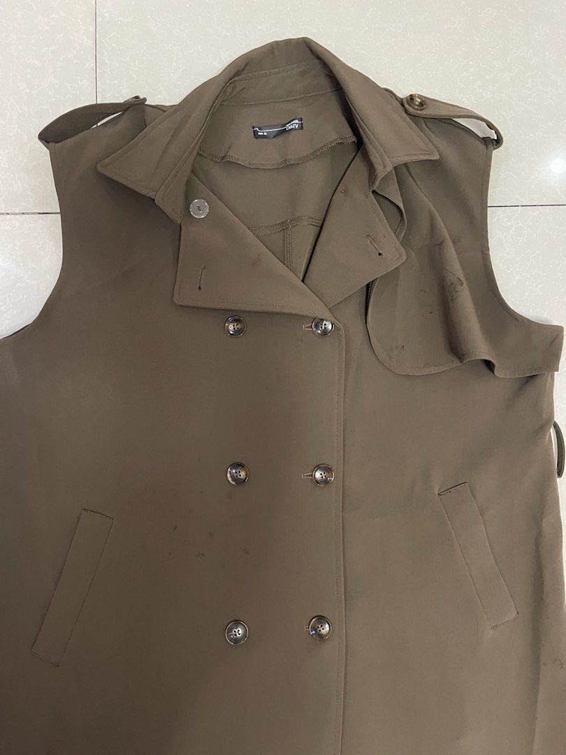 Brown Sleeveless Double-Breasted Trench Coat (Category: Coats, Jackets and Outerwear) located in Manila. Submitted by offtherack_mnl (Listing ID 1450758269, Image 2). Description: - Brown sleeveless trench coat - Double-breasted with button closure - Front pockets - Belt loops on sides - Ideal for layering - Minor marks present (please check photos).