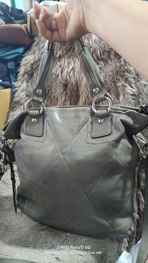 Coach Leather Satchel Bag Grey Quilted (Category: Luxury Bags & Wallets) located in Manila. Submitted by wildwind_49ab7e (Listing ID 1450771952, Image 2). Description: - Genuine grey leather Coach satchel bag - Secure turn-lock closure on front pocket - Spacious interior with multiple compartments - Includes a detachable shoulder strap for versatile carrying - Leather shows some signs of wear, particularly on the base - Ideal for everyday use.