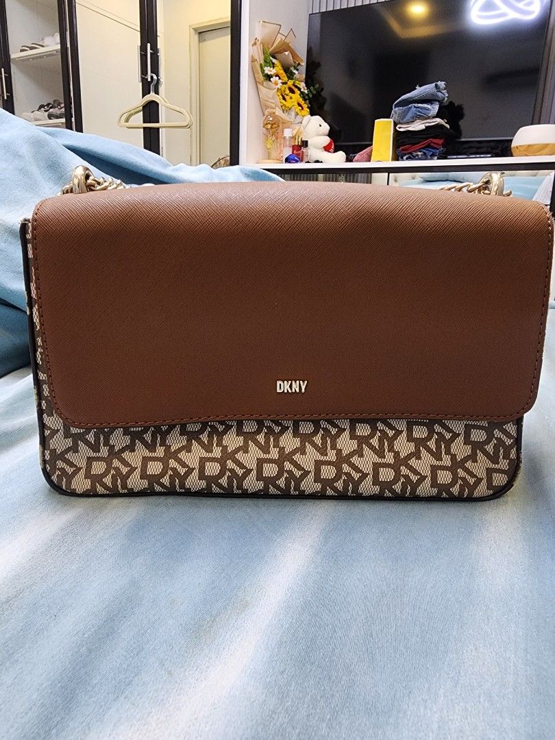 DKNY Sina Medium Flap Bag Original 100% (Category: Luxury Bags & Wallets) located in Quezon City. Submitted by pinkyshang (Listing ID 1450779201, Image 1). Description: - DKNY shoulder bag - Color: Brown - Features classic DKNY monogram print on one sid - Plain brown leather on the other side - Gold chain strap - Interior with multiple compartments and a zip pocket - Versatile for everyday use or evening outings - Bought this at 9,000 pesos, now 