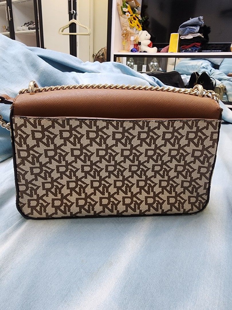 DKNY Sina Medium Flap Bag Original 100% (Category: Luxury Bags & Wallets) located in Quezon City. Submitted by pinkyshang (Listing ID 1450779201, Image 2). Description: - DKNY shoulder bag - Color: Brown - Features classic DKNY monogram print on one sid - Plain brown leather on the other side - Gold chain strap - Interior with multiple compartments and a zip pocket - Versatile for everyday use or evening outings - Bought this at 9,000 pesos, now 