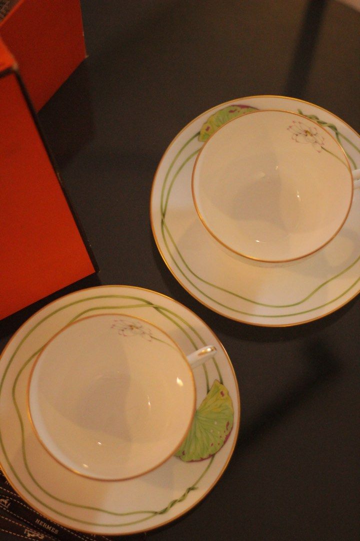 Hermes Tea Cup Nil Collection (Category: Coffee & Tea Tableware) located in Quezon City. Submitted by maria___x (Listing ID 1450780785, Image 2). Description: - Set of 2 authentic Hermes tea cups and saucers. - Elegant lotus flower and lily pad design. - Comes with original Hermes box and ribbon. - Crafted from high-quality porcelain. - Adds a luxurious touch to your tea time. - Ideal gift for tea enthusiasts..