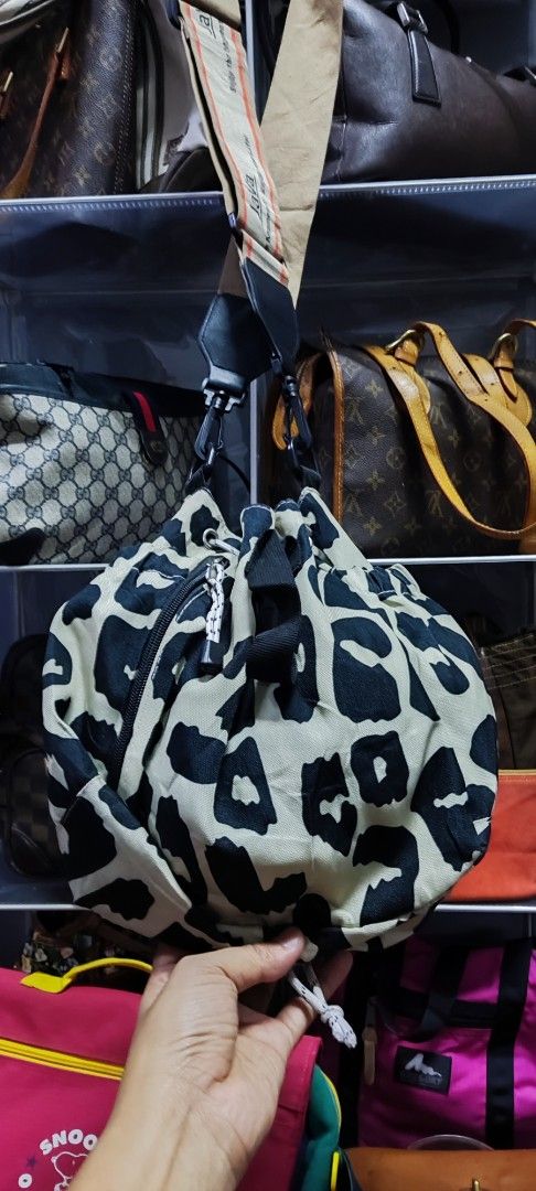 JAVA Leopard Print Drawstring Bucket Bag (Category: Cross-body Bags) located in Machang. Submitted by yie_bundle (Listing ID 1450891339, Image 2). Description: - Cute leopard print drawstring bag from JAVA. - Features a wide strap with JAVA branding. - Unique cinched shape when closed. - Ideal for everyday use or travel. - Spacious interior for your essentials. - Secure drawstring closure. - Includes a convenient shoulder strap..