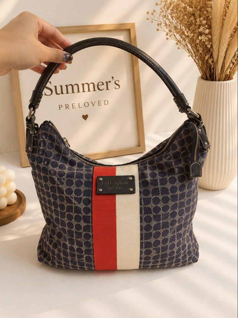 Kate Spade tote Bag (Category: Luxury Bags & Wallets) located in Taguig. Submitted by summers.preloved (Listing ID 1450841123, Image 1). Description: - Navy blue Kate Spade hobo bag - Classic all-over spade pattern - Red and cream stripe detail on the front - Genuine leather handles and trim - Vibrant red interior lining - Spacious main compartment - Secure zipper closure.