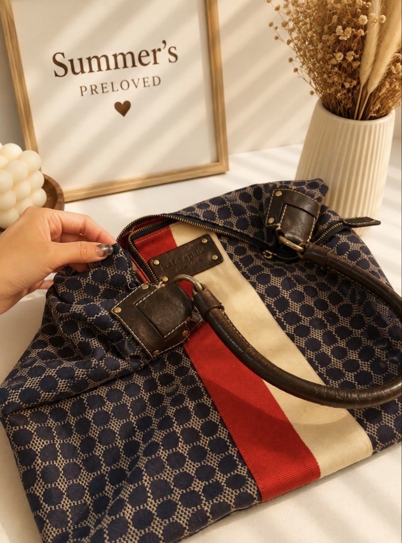 Kate Spade tote Bag (Category: Luxury Bags & Wallets) located in Taguig. Submitted by summers.preloved (Listing ID 1450841123, Image 3). Description: - Navy blue Kate Spade hobo bag - Classic all-over spade pattern - Red and cream stripe detail on the front - Genuine leather handles and trim - Vibrant red interior lining - Spacious main compartment - Secure zipper closure.