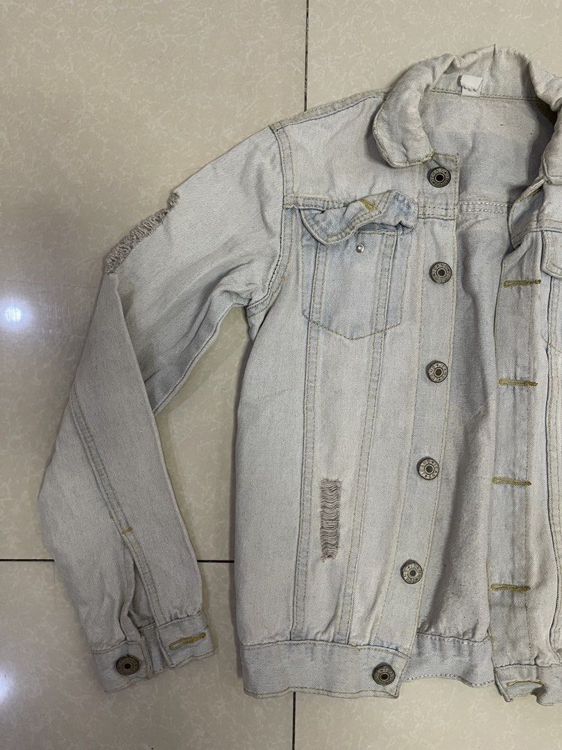 Light Wash Distressed Denim Jacket with Superman Logo (Category: Coats, Jackets and Outerwear) located in Manila. Submitted by offtherack_mnl (Listing ID 1450755692, Image 2). Description: - Light wash denim jacket - Distressed details on sleeves and front - Button-up closure - Two chest pockets - Long sleeves with button cuffs - Casual and cool style - Ideal for layering.