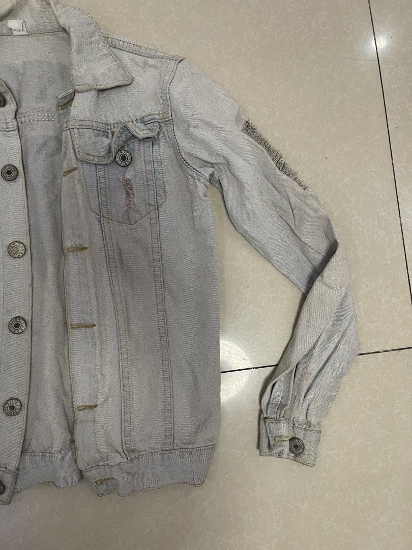 Light Wash Distressed Denim Jacket with Superman Logo (Category: Coats, Jackets and Outerwear) located in Manila. Submitted by offtherack_mnl (Listing ID 1450755692, Image 3). Description: - Light wash denim jacket - Distressed details on sleeves and front - Button-up closure - Two chest pockets - Long sleeves with button cuffs - Casual and cool style - Ideal for layering.
