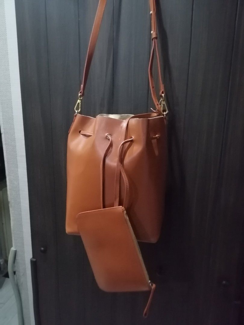 Mansur Gavriel Bucket Bag with Pouch - Tan Leather (Category: Luxury Bags & Wallets) located in Pasay City. Submitted by 22spc (Listing ID 1450899668, Image 2). Description: - Genuine tan leather bucket bag - Comes with a matching leather pouch - Secure drawstring closure - Adjustable shoulder strap for comfort - Unlined interior with ample storage space - Beautiful natural leather patina Inside edges needs repair, or pasting of edges.