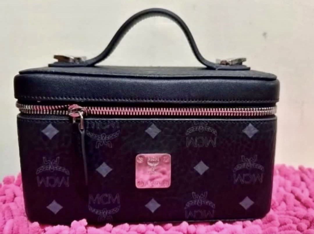 MCM vanity case with strap (Category: Cross-body Bags) located in Pasay City. Submitted by taptooload (Listing ID 1450874135, Image 2). Description: - Signature MCM logo pattern - Black exterior - Top handle - Zip-around closure - Lined interior - Detachable strap - Silver-tone hardware In great condition actual picture posted very nice in actual.
