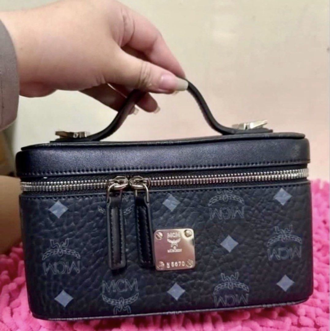 MCM vanity case with strap (Category: Cross-body Bags) located in Pasay City. Submitted by taptooload (Listing ID 1450874135, Image 3). Description: - Signature MCM logo pattern - Black exterior - Top handle - Zip-around closure - Lined interior - Detachable strap - Silver-tone hardware In great condition actual picture posted very nice in actual.