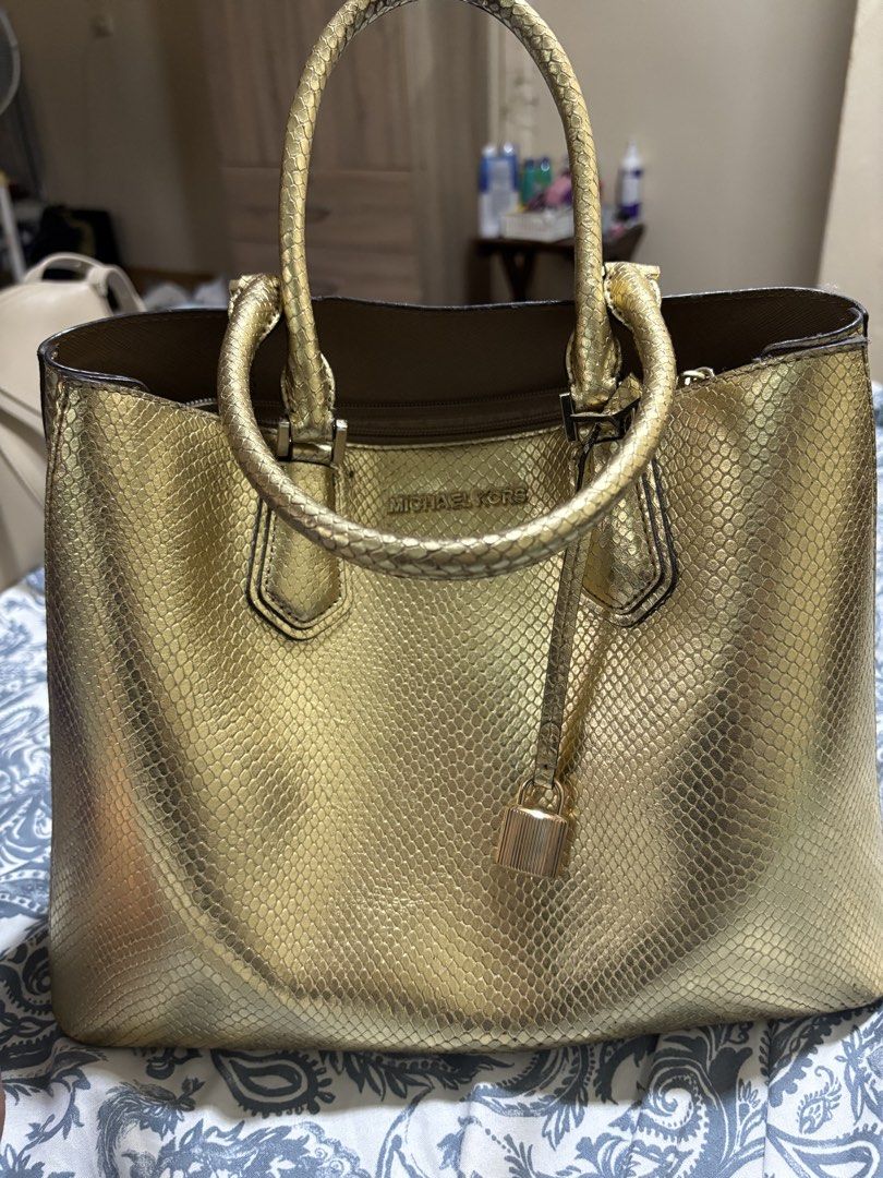 Michael Kors (Category: Luxury Bags & Wallets) located in Iloilo. Submitted by sg0313 (Listing ID 1450779227, Image 3). Description: - Authentic Michael Kors Mercer in snakeskin elegant gold. Bought in Texas last January for $350 dollars. Only used twice as I stay at the farm. Selling low as need to declutt. - Features a stylish all-over snakeskin texture. - Includes a detachable shoulder strap for versatile carrying options. - Adorned with a sig