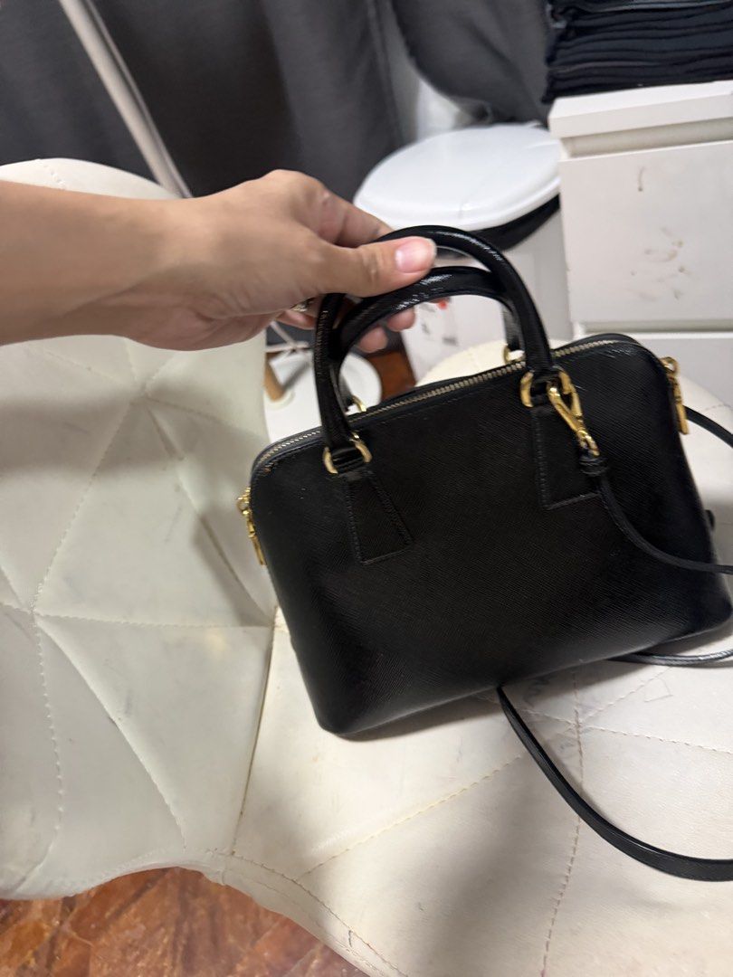 Prada Saffiano Leather Black Top Handle Bag (Category: Luxury Bags & Wallets) located in Quezon City. Submitted by jmscm (Listing ID 1450819602, Image 3). Description: Guaranteed Authentic -size Small - Classic black Prada bag - Genuine Saffiano leather - Elegant gold hardware details - Includes a detachable shoulder strap - Multiple interior compartments and a zip pocket - Very structured, maintains its shape - Perfect for daily use or special e