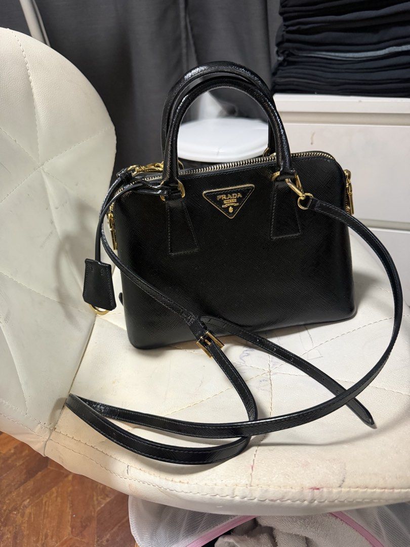 Prada Saffiano Leather Black Top Handle Bag (Category: Luxury Bags & Wallets) located in Quezon City. Submitted by jmscm (Listing ID 1450819602, Image 1). Description: Guaranteed Authentic -size Small - Classic black Prada bag - Genuine Saffiano leather - Elegant gold hardware details - Includes a detachable shoulder strap - Multiple interior compartments and a zip pocket - Very structured, maintains its shape - Perfect for daily use or special e