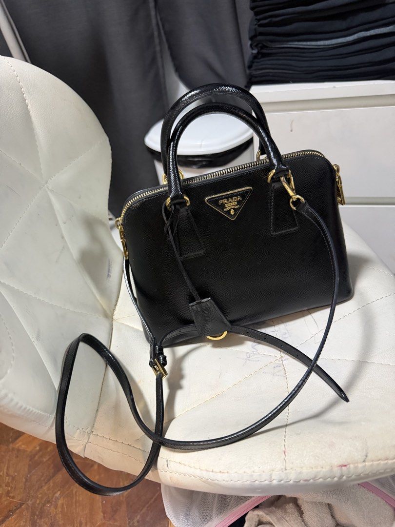 Prada Saffiano Leather Black Top Handle Bag (Category: Luxury Bags & Wallets) located in Quezon City. Submitted by jmscm (Listing ID 1450819602, Image 2). Description: Guaranteed Authentic -size Small - Classic black Prada bag - Genuine Saffiano leather - Elegant gold hardware details - Includes a detachable shoulder strap - Multiple interior compartments and a zip pocket - Very structured, maintains its shape - Perfect for daily use or special e