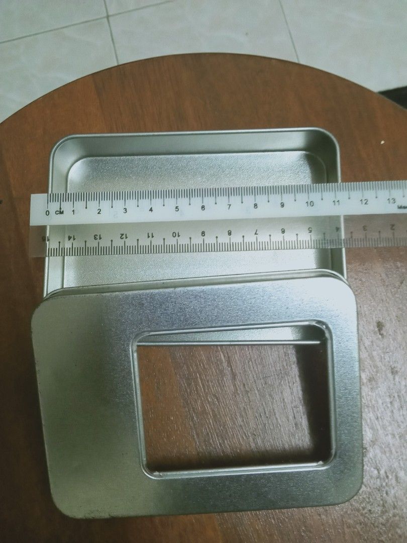 Rectangular Tin Box with Window (Category: Magazines) located in Rawang. Submitted by pasarkaratonline90 (Listing ID 1450768893, Image 2). Description: - Sleek silver rectangular tin box - Features a clear window on the lid for easy viewing - Ideal for organizing small items, crafts, or as a charming gift box - Approximate dimensions: 14.5 cm (length) x 9.5 cm (width) - Comes empty, ready for your personal touch or storage needs - Inquire if you 