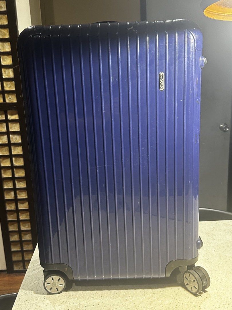 Rimowa Check In Luggage (Category: Luggage) located in Muntinlupa City. Submitted by goodsbymjp (Listing ID 1447106293, Image 1). Description: - Classic blue Rimowa suitcase with iconic ribbed design. - Shows expected signs of wear from travel, adding character. - Wheels are intact and fully functional, ready to roll. - Perfect for short trips or as a convenient carry-on. -with crack photo at last part but not obvious and not an issue with the fu