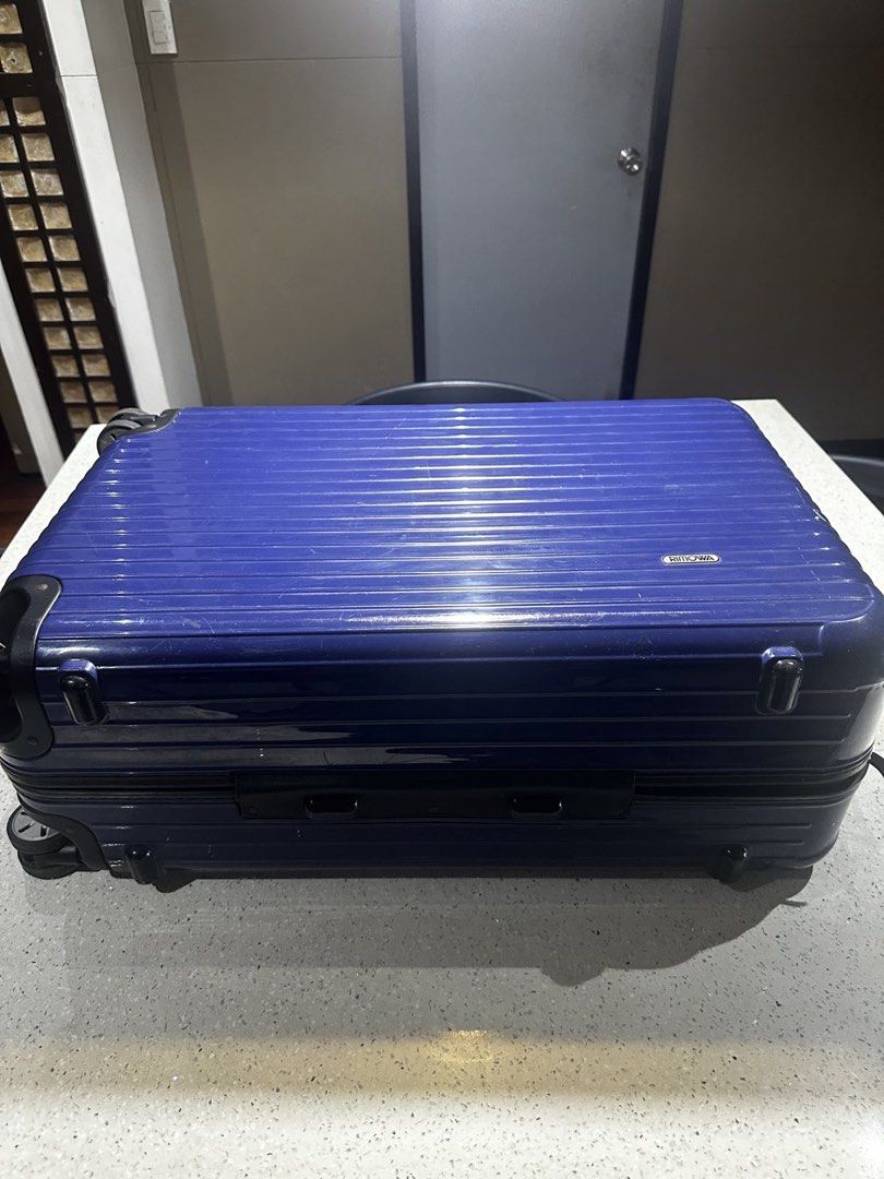Rimowa Check In Luggage (Category: Luggage) located in Muntinlupa City. Submitted by goodsbymjp (Listing ID 1447106293, Image 3). Description: - Classic blue Rimowa suitcase with iconic ribbed design. - Shows expected signs of wear from travel, adding character. - Wheels are intact and fully functional, ready to roll. - Perfect for short trips or as a convenient carry-on. -with crack photo at last part but not obvious and not an issue with the fu