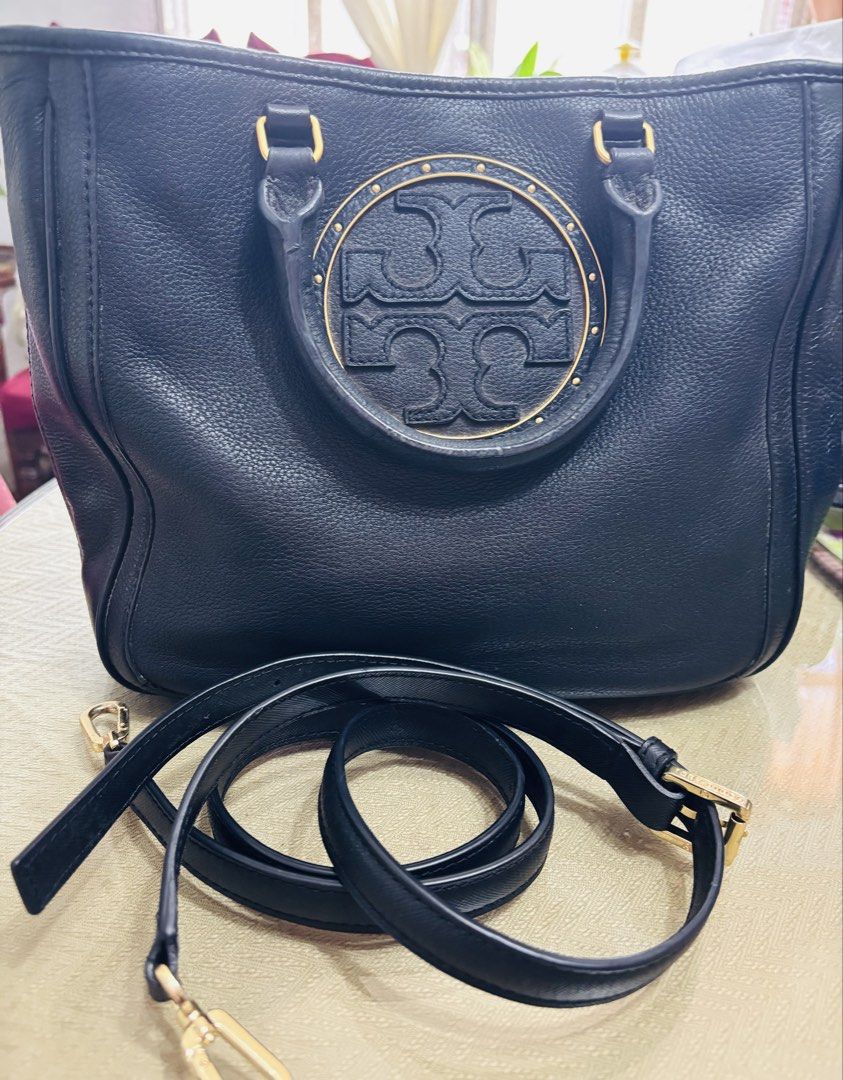Tory Burch Black Leather Tote Bag with Shoulder Strap (Category: Luxury Bags & Wallets) located in Indang. Submitted by lornacmtl (Listing ID 1450781205, Image 1). Description: - Genuine black leather Tory Burch tote bag - Includes a detachable shoulder strap - Elegant gold hardware details - Spacious interior for all your essentials - Ideal for everyday use.