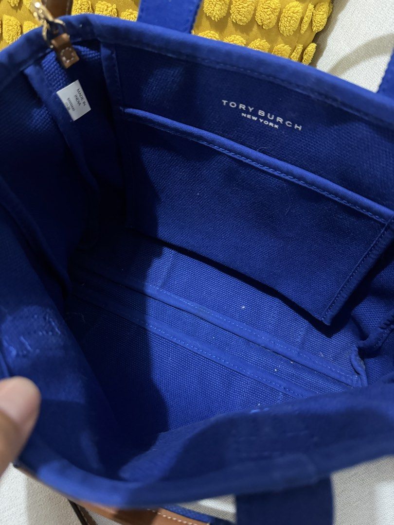 Tory Burch Canvas Tote Bag Blue (Category: Luxury Bags & Wallets) located in Paranaque City. Submitted by mweowmyganda (Listing ID 1450862424, Image 3). Description: - Blue Tory Burch canvas tote bag - Genuine leather handles and strap - Interior slip pocket for organization - 'Tory Burch New York' logo on the front - Made in India - Ideal for everyday use Hardware: gold tone stainless steel, polish finished Exterior: printed white logo Interior: