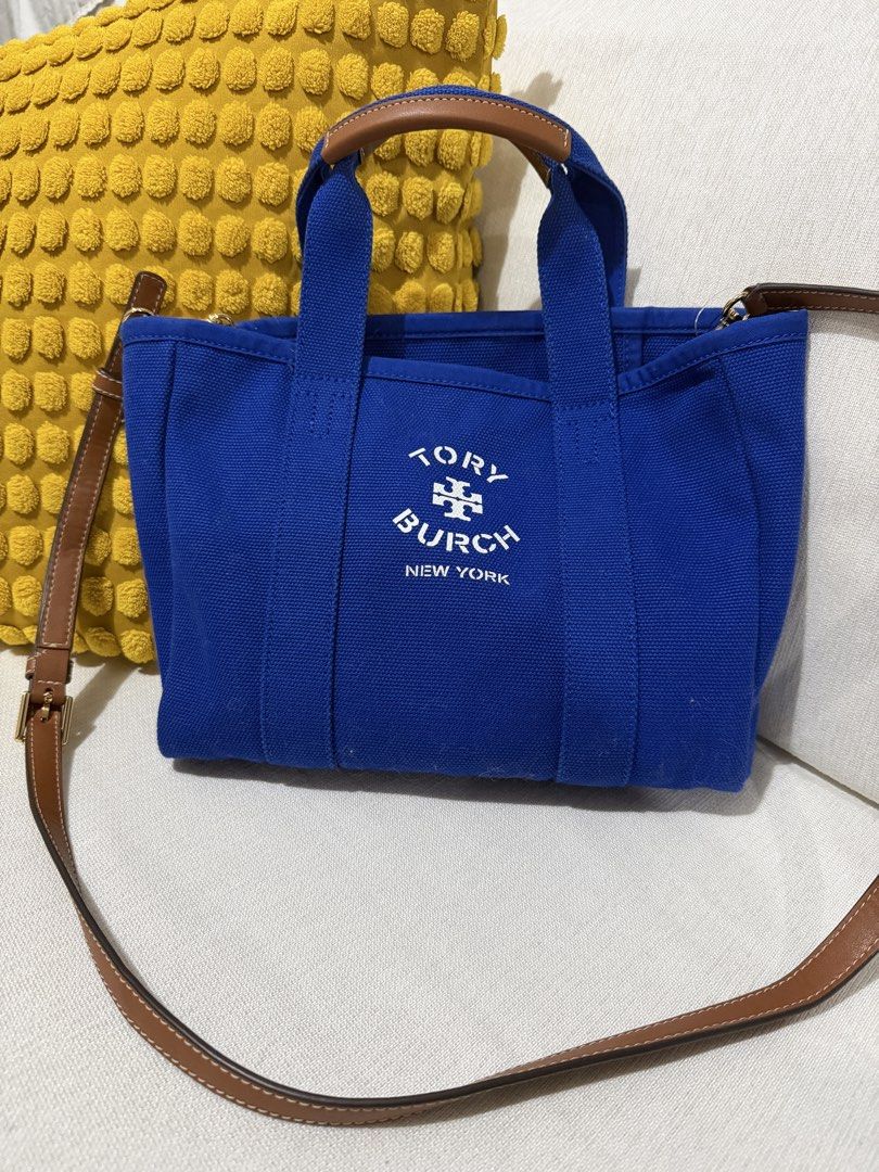 Tory Burch Canvas Tote Bag Blue (Category: Luxury Bags & Wallets) located in Paranaque City. Submitted by mweowmyganda (Listing ID 1450862424, Image 1). Description: - Blue Tory Burch canvas tote bag - Genuine leather handles and strap - Interior slip pocket for organization - 'Tory Burch New York' logo on the front - Made in India - Ideal for everyday use Hardware: gold tone stainless steel, polish finished Exterior: printed white logo Interior: