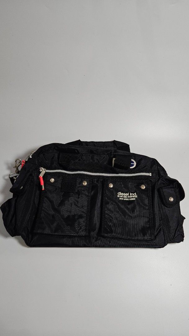 vintage Diesel multi pocket tactical utility bag (Category: Luxury Bags & Wallets) located in Alfonso. Submitted by jbcamet (Listing ID 1450849732, Image 1). Description: - Black Diesel bag - Bright orange interior lining - Silver zippers and clasps - Red accents on zipper pulls - Ideal for carrying essentials.