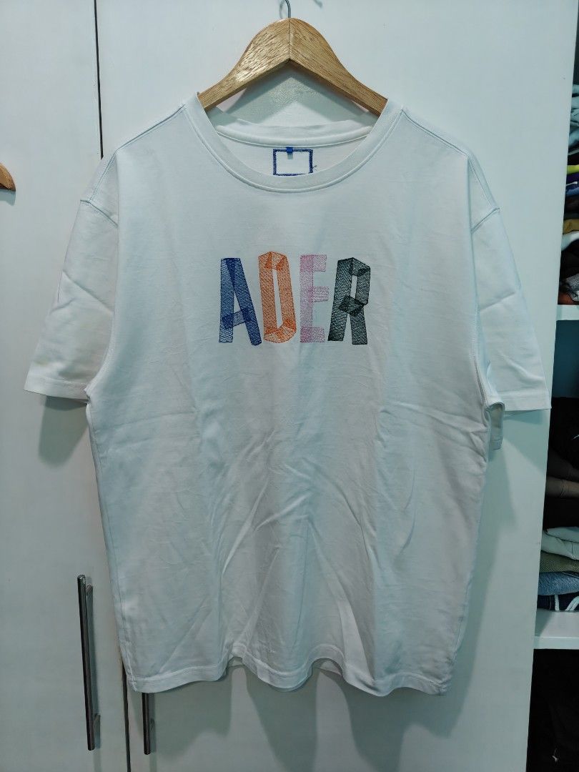 ADER Error White Embroidered Logo T-Shirt Size A2 (Category: Tshirts & Polo Shirts ) located in Quezon City. Submitted by lancelooot (Listing ID 1451009989, Image 1). Description: - Brand: ADER Error - Color: Off-white - Size: A2 (22x28) - Collection: 2021 Spring Summer - Front Detail: Embroidered multi-color 'ADER' logo - Back Detail: Small embroidered logo near collar - Material: 75% Cotton, 25% Polyester.