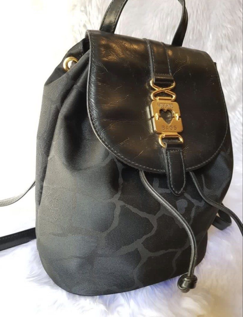 Rush Sale!Authentic Preloved Moschino Backpack (Category: Luxury Bags & Wallets) located in Baguio. Submitted by designerbin.ph (Listing ID 1451085675, Image 2). Description: Authentic Preloved Moschino Backpack Moschino Bags Japan Condition: In good condition with some signs of normal use. No damage or whatsoever. Rate: 8/10. Measurement: H - 22 cm W - 26 cm D - 15 cm Inclusion/s: None Authenticity: Money back if proven fake.