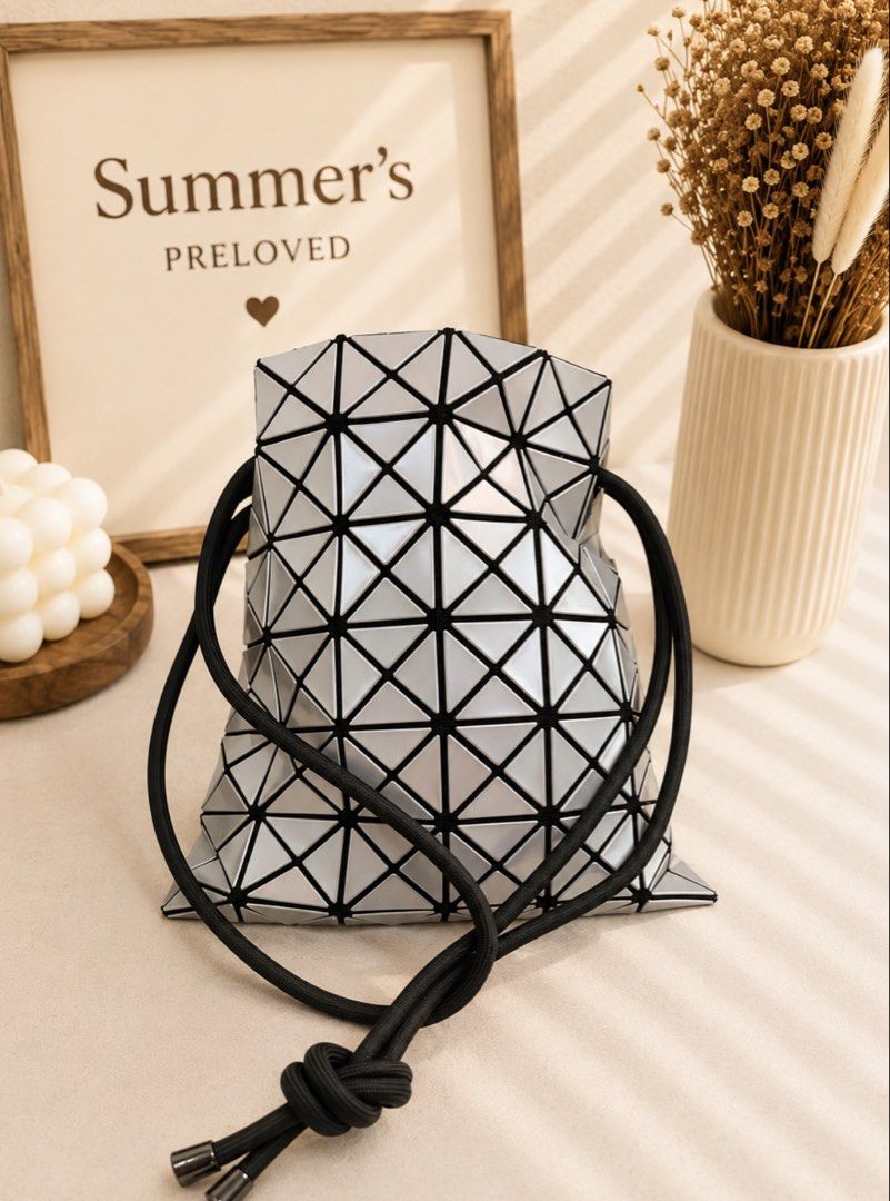 BAOBAO Bucket Bag (Category: Luxury Bags & Wallets) located in Taguig. Submitted by summers.preloved (Listing ID 1451122430, Image 1). Description: - Unique geometric prism design bucket bag - Sleek silver color with black trim - Secure drawstring closure - Perfect for adding flair to any outfit or for a night out - Features a small interior pocket - Comes with a protective dust bag.