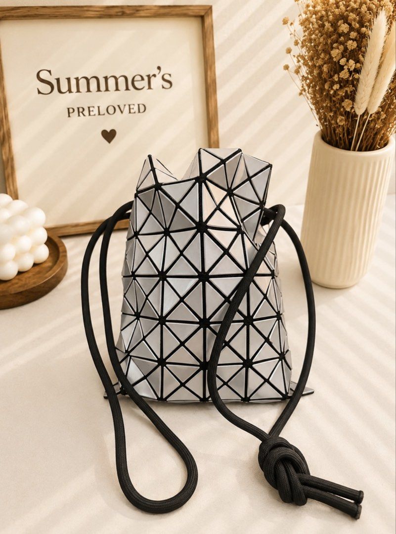 BAOBAO Bucket Bag (Category: Luxury Bags & Wallets) located in Taguig. Submitted by summers.preloved (Listing ID 1451122430, Image 3). Description: - Unique geometric prism design bucket bag - Sleek silver color with black trim - Secure drawstring closure - Perfect for adding flair to any outfit or for a night out - Features a small interior pocket - Comes with a protective dust bag.
