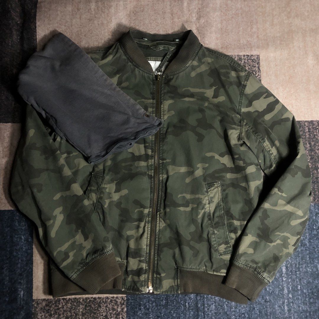 Camo Bomber Jacket with Grey Hood (Category: Coats, Jackets and Outerwear) located in Dasmarinas. Submitted by johnlloydm99208 (Listing ID 1451058633, Image 2). Description: - Green camouflage bomber jacket - Features a grey contrast hood - Ribbed cuffs and hem for a snug fit - Zipper closure for easy wear - Two convenient front pockets - Ideal for casual outfits, pairs well with jeans or joggers - 23x26.