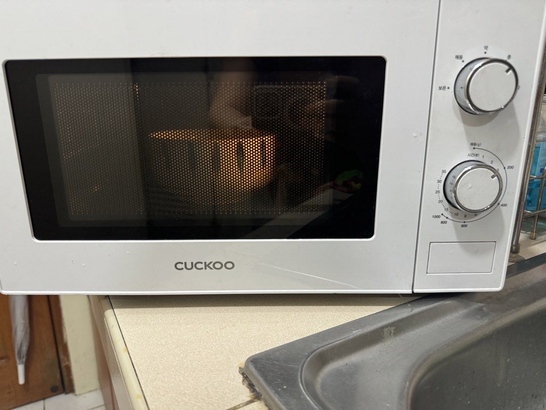 Cuckoo Microwave Oven (Category: Ovens & Toasters) located in Makati City. Submitted by lovejuju72 (Listing ID 1451086904, Image 1). Description: - White Cuckoo microwave oven - Two control knobs for time and power settings - Interior light illuminates when in use - Ideal for quick meals and reheating - Compact design, fits well on kitchen countertops.