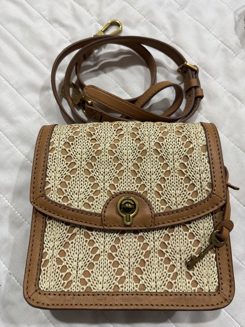 Fossil Woven Leather Crossbody Bag (Category: Cross-body Bags) located in Shah Alam. Submitted by prelovedbypunk (Listing ID 1451079417, Image 1). Description: - Cute Fossil crossbody bag - Tan leather trim with woven straw-like body - Secure turn-lock closure - Long, adjustable strap - Interior with multiple compartments - Small scuff marks on leather trim (adds character!) - Ideal for everyday wear and casual outings.