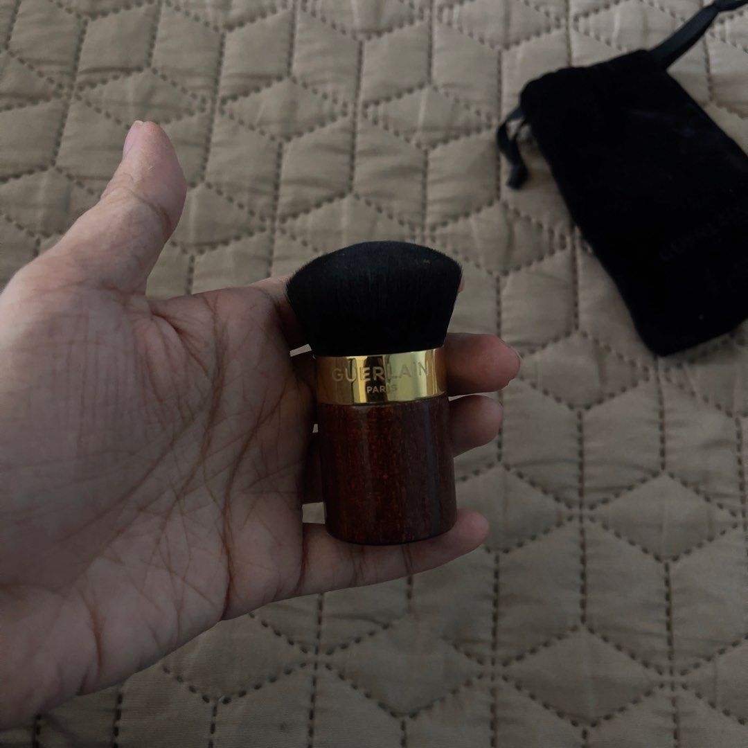 Guerlain Kabuki Makeup Brush with Pouch (Category: Makeup) located in Naga. Submitted by katalinaii (Listing ID 1450977870, Image 3). Description: Guerlain Kabuki Brush Purchased at Greenbelt 5 in 2023 Brush is in great condition Wooden handle with gold accent Compact size Comes with original black velvet pouch, just a bit flaky on the inside already Original price was about 3,500 Only used a few times.