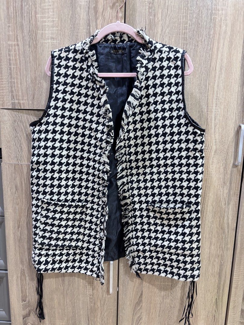 Houndstooth Fringe Vest (Category: Vests) located in Manila. Submitted by laijane (Listing ID 1450950312, Image 1). Description: - Stylish black and white houndstooth pattern vest - Sleeveless design - Unique fringe details on open front and hem - Fully lined for comfort - Versatile for layering over tops or dresses - Adds a unique touch to any outfit Bust size: 42 cm Length 48 cm.