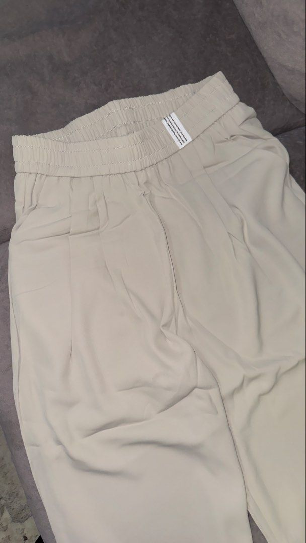 Light Beige Pants (from Bangkok) (Category: Other Bottoms) located in Kuala Lumpur. Submitted by fararsd (Listing ID 1451117921, Image 2). Description: - Light beige wide leg pants - Comfortable elastic waistband - Stylish pleated front detail - Relaxed fit for a casual look - Versatile for casual or dressed-up outfits - Brand new, still in original packaging.