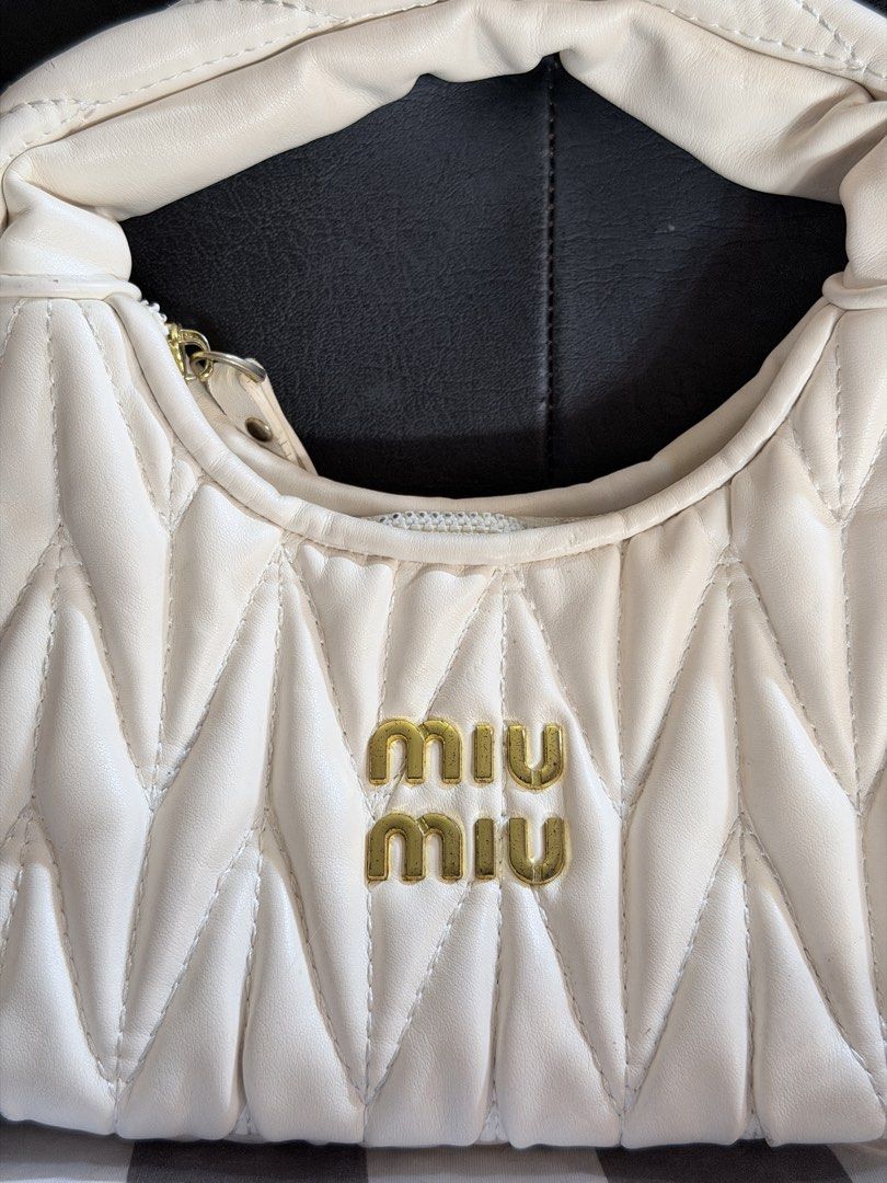 Miu Miu Quilted Cream Handbag (small sized) (Category: Luxury Bags & Wallets) located in Manila. Submitted by jasminefai11057 (Listing ID 1450998834, Image 2). Description: - Cream quilted handbag - Iconic gold Miu Miu logo - Versatile top handle and detachable shoulder strap - Elegant gold hardware details - Secure zipper closure -No box - Ideal for everyday wear or evening events.