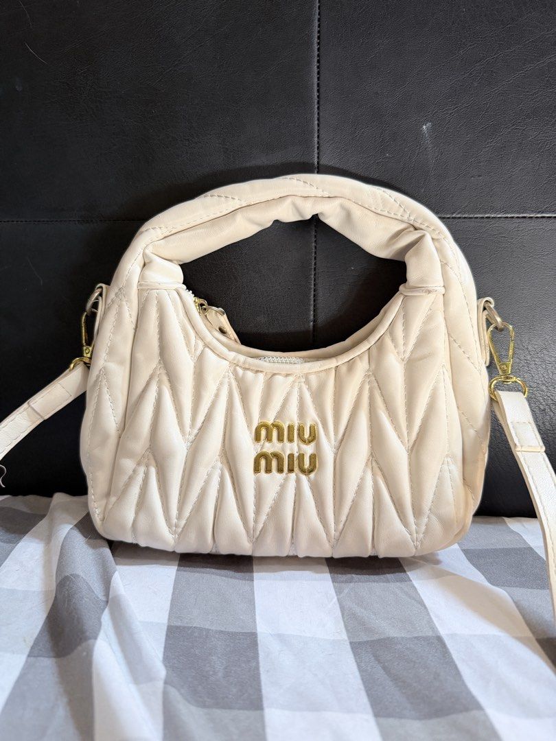 Miu Miu Quilted Cream Handbag (small sized) (Category: Luxury Bags & Wallets) located in Manila. Submitted by jasminefai11057 (Listing ID 1450998834, Image 1). Description: - Cream quilted handbag - Iconic gold Miu Miu logo - Versatile top handle and detachable shoulder strap - Elegant gold hardware details - Secure zipper closure -No box - Ideal for everyday wear or evening events.