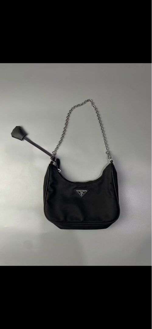 Prada Re-Edition 2000 Nylon Shoulder Bag Black (Category: Luxury Bags & Wallets) located in Manila. Submitted by matcha.archive (Listing ID 1451061267, Image 1). Description: - Classic Prada shoulder bag - Black nylon material - Silver chain strap - Includes leather tag - Small and compact, ideal for essentials - Versatile style.