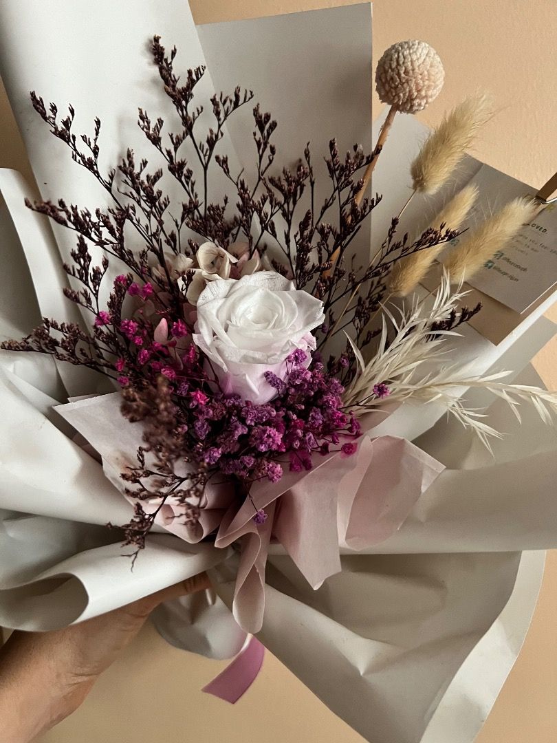 Preserved Rose & Dried Flower Bouquet (Category: Flowers & Bouquets) located in Cebu City. Submitted by carou75847 (Listing ID 1451019189, Image 2). Description: - Beautiful preserved rose and dried flower bouquet. - Features purple statice, bunny tails, and other dried elements. - Wrapped in elegant white and grey paper. - Finished with a delicate pale pink ribbon. - Ideal for gifting or adding a touch of charm to your home decor. - Ready to dis