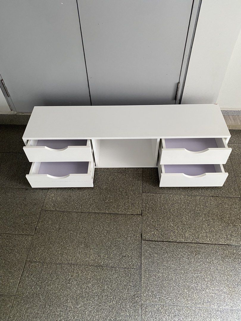 Tv console (Category: Shelves, Cabinets & Racks) located in Singapore. Submitted by nurmoammad (Listing ID 1450944607, Image 2). Description: - White storage cabinet - Four drawers with cut-out handles - Central open shelf - Light purple drawer lining - Ideal for organizing small items - Dimensions: Approximately 120cm (length).