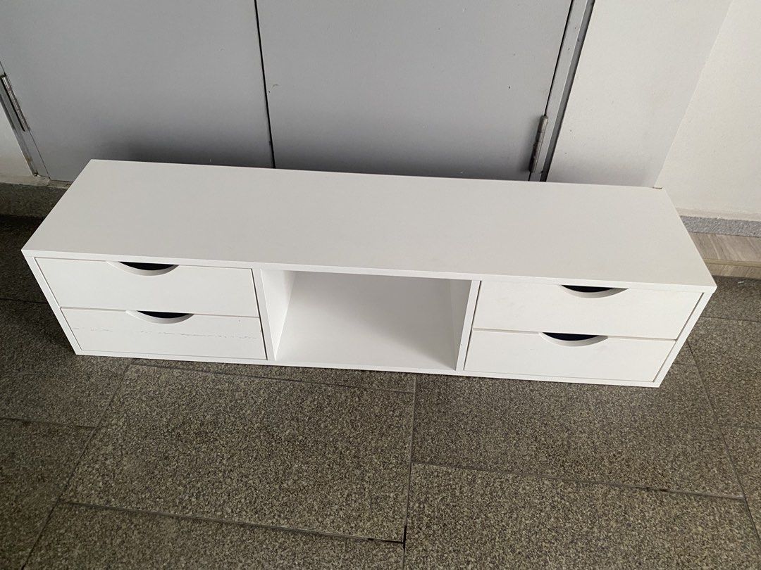 Tv console (Category: Shelves, Cabinets & Racks) located in Singapore. Submitted by nurmoammad (Listing ID 1450944607, Image 1). Description: - White storage cabinet - Four drawers with cut-out handles - Central open shelf - Light purple drawer lining - Ideal for organizing small items - Dimensions: Approximately 120cm (length).