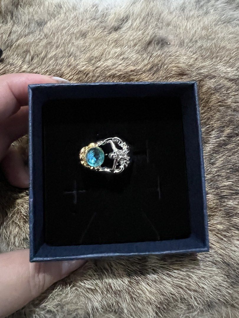 Unique Silver and Gold Ring with Blue Gemstone (Category: Rings) located in Manila. Submitted by evvvcloset (Listing ID 1451123322, Image 1). Description: - Eye-catching ring with a vibrant blue stone. - Intricate detailing on the silver band. - Elegant gold accents surrounding the stone. - Unique and distinctive design. - Includes a stylish dark blue presentation box. - Perfect for making a statement..