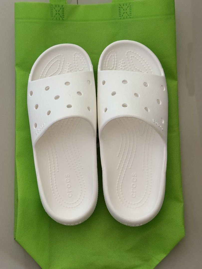 White Crocs Classic Slide Sandals (Category: Slippers and slides) located in Taguig. Submitted by atg.online.shop (Listing ID 1451085448, Image 2). Description: RFS: too small, decluttering Used only once - Classic white Crocs slides - Features ventilation holes for breathability - Easy slip-on, slip-off design - Durable sole with Crocs logo and size details - Ideal for casual wear or post-activity comfort - Lightweight and comfortable - Includes