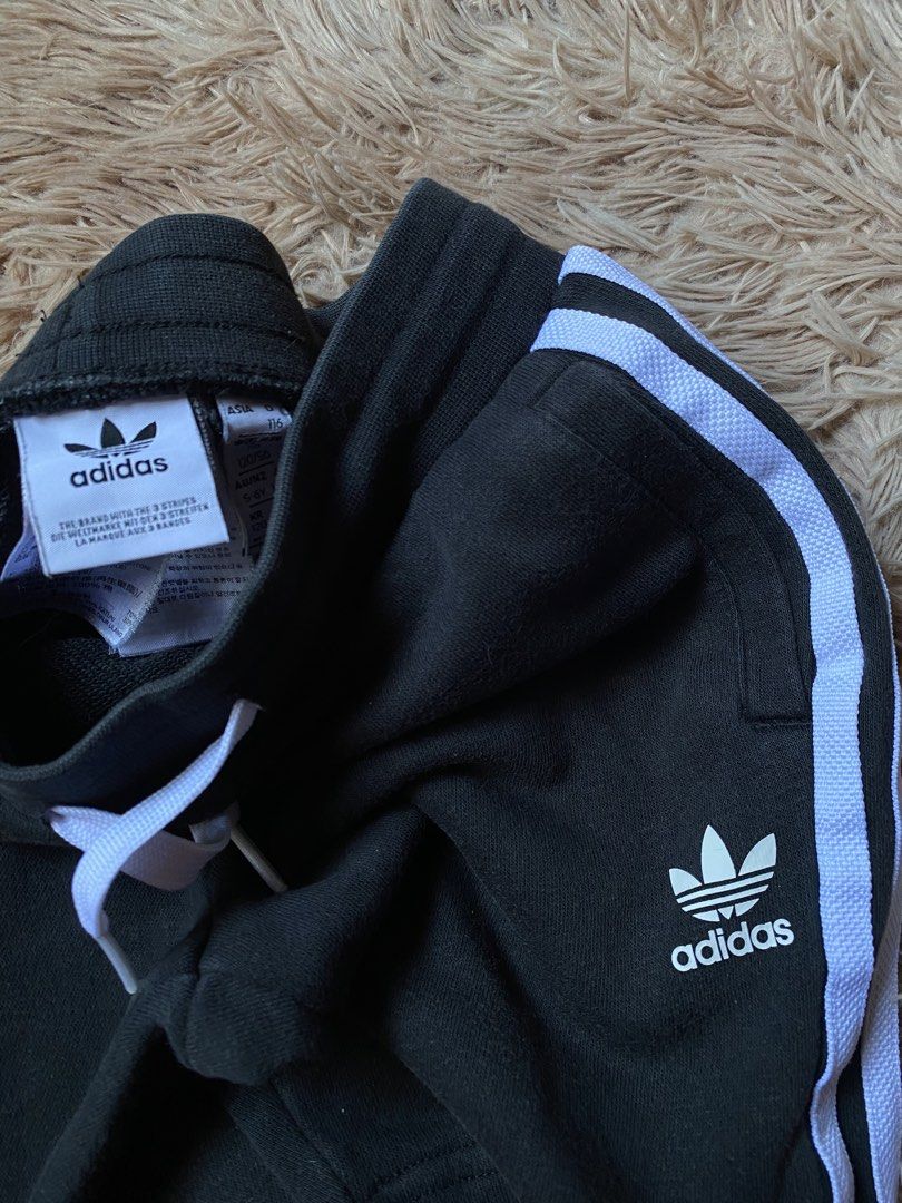 Adidas Black Shorts with White Stripes (Category: Babies & Kids Fashion) located in Manila. Submitted by stormibutterfly26 (Listing ID 1451168102, Image 2). Description: - Classic black Adidas shorts - Iconic white side stripes - Comfortable elastic waistband with drawstring - Two convenient side pockets - Versatile for sports or casual wear - Features the Adidas logo.