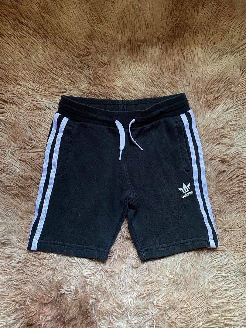 Adidas Black Shorts with White Stripes (Category: Babies & Kids Fashion) located in Manila. Submitted by stormibutterfly26 (Listing ID 1451168102, Image 1). Description: - Classic black Adidas shorts - Iconic white side stripes - Comfortable elastic waistband with drawstring - Two convenient side pockets - Versatile for sports or casual wear - Features the Adidas logo.