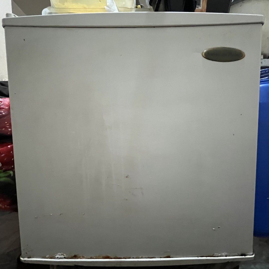American Home Mini Fridge (Category: Refrigerators and Freezers) located in Mandaluyong City. Submitted by theosystem (Listing ID 1451232509, Image 1). Description: - White American Home mini fridge - Works well, ideal for dorm rooms or small offices - Shows some signs of wear and tear, particularly at the bottom - Interior is clean - Temperature control knob included ISSUE: DOOR HINGE NEEDS REPAIR DUE TO RUSTS.