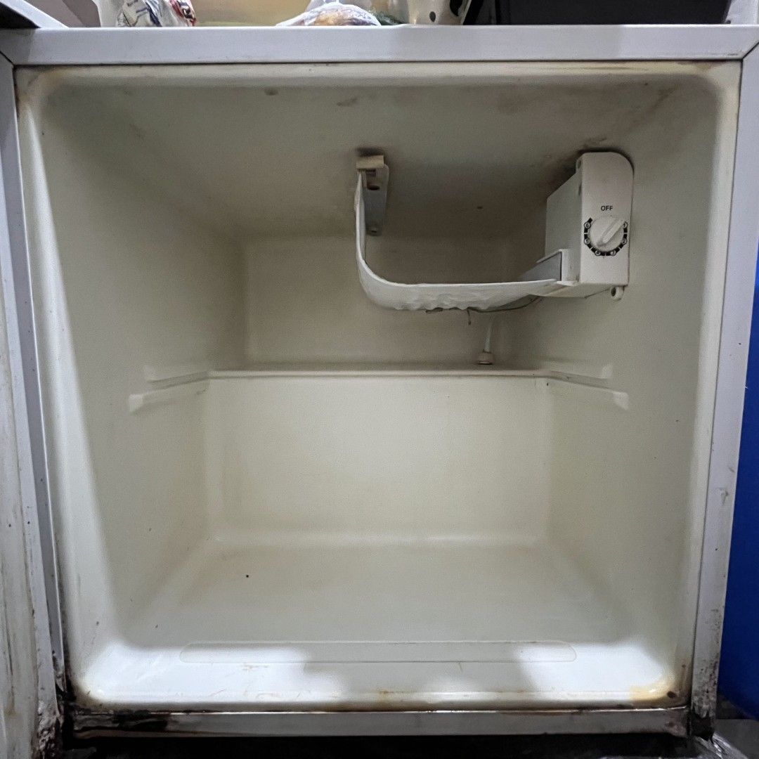 American Home Mini Fridge (Category: Refrigerators and Freezers) located in Mandaluyong City. Submitted by theosystem (Listing ID 1451232509, Image 2). Description: - White American Home mini fridge - Works well, ideal for dorm rooms or small offices - Shows some signs of wear and tear, particularly at the bottom - Interior is clean - Temperature control knob included ISSUE: DOOR HINGE NEEDS REPAIR DUE TO RUSTS.