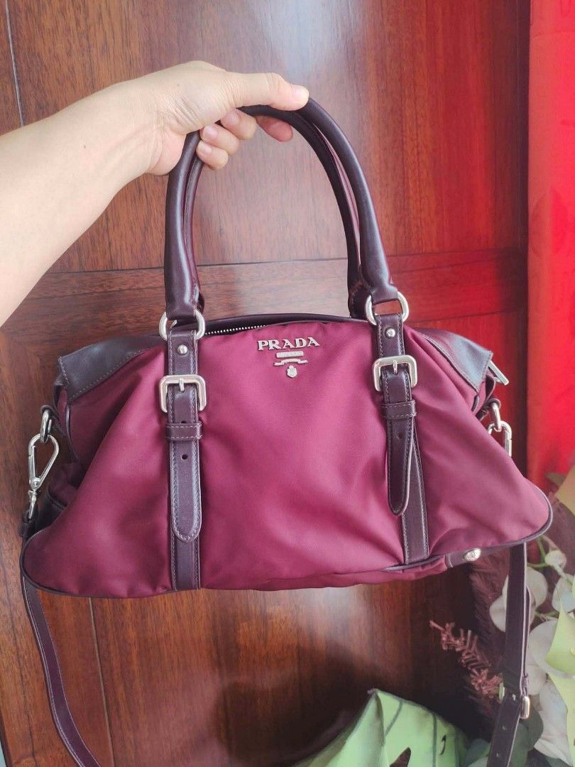Authentic Prada Nylon Leather Trim Satchel Bag (Category: Luxury Bags & Wallets) located in Cebu City. Submitted by tlisurplus (Listing ID 1451173002, Image 2). Description: - Authentic Prada bag - Color: Burgundy nylon with leather trim - Features: Top handles and detachable shoulder strap - Closure: Zipper - Interior: Multiple compartments - Authentication: Verified by Dr. Runway - Versatile: Ideal for daily use or special occasions.
